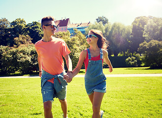 Image showing happy teenage couple walking at summer park