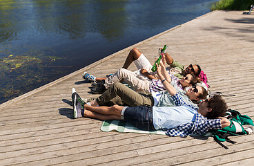 Image showing friends drinking beer and cider on lake pier