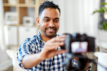 Image showing indian male video blogger adjusting camera at home