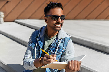 Image showing indian man with notebook or sketchbook on roof top