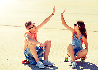 Image showing teenage couple with skateboards on city street