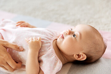 Image showing baby girl lying on blanket and mother\'s hand