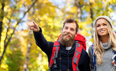 Image showing smiling couple with backpacks hiking in autumn