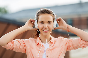 Image showing happy teenage girl with headphones in city