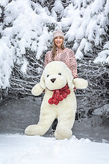 Image showing Woman out in the snow with a large soft toy