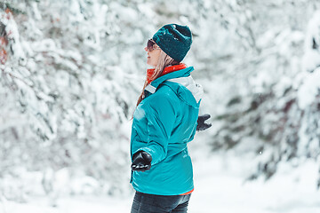 Image showing Woman standing out in falling snow in winter