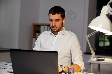 Image showing businessman with laptop working at night office