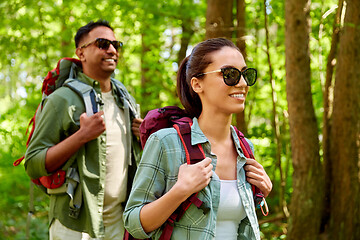 Image showing mixed race couple with backpacks hiking in forest