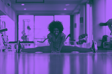 Image showing woman in a gym stretching and warming up before workout