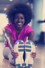 Image showing woman in a gym stretching and warming up before workout