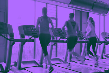 Image showing Group of people running on treadmills