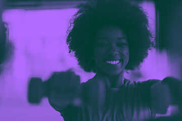 Image showing woman working out in a crossfit gym with dumbbells