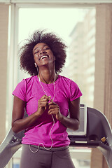 Image showing afro american woman running on a treadmill