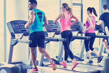 Image showing Group of people running on treadmills