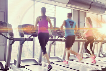 Image showing Group of people running on treadmills