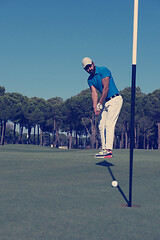 Image showing golf player hitting shot at sunny day