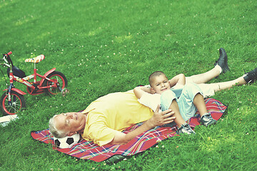 Image showing grandfather and child in park using tablet