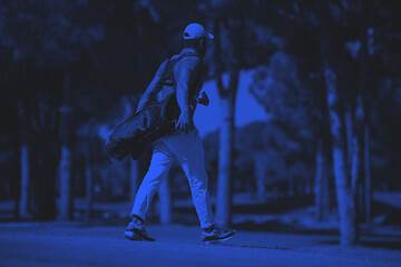 Image showing golf player walking and carrying bag