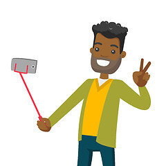 Image showing A black man making selfie on his cellphone with a selfie stick.