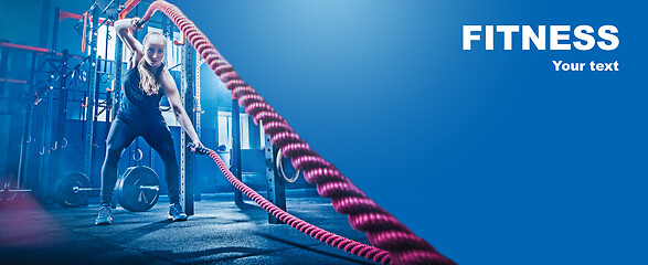 Image showing Woman with battle rope battle ropes exercise in the fitness gym.