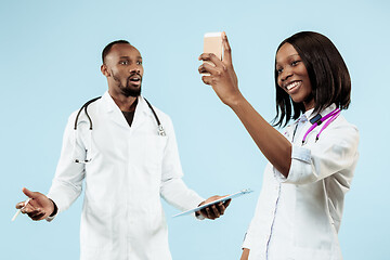 Image showing The female and male happy afro american doctors on blue background