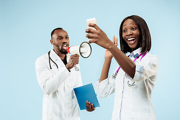 Image showing The female and male happy afro american doctors on blue background