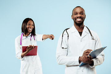 Image showing The female and male happy afro american doctors on blue background