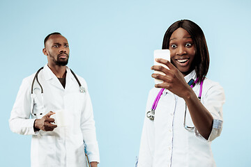 Image showing The female and male happy afro american doctors on blue background