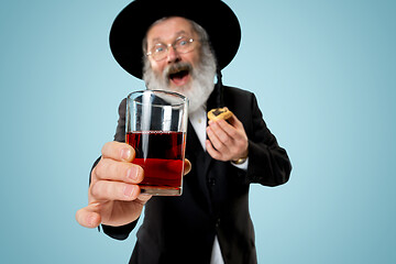 Image showing The senior orthodox Jewish man with black hat with Hamantaschen cookies for Jewish festival of Purim