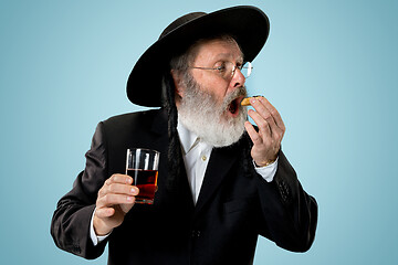 Image showing The senior orthodox Jewish man with black hat with Hamantaschen cookies for Jewish festival of Purim