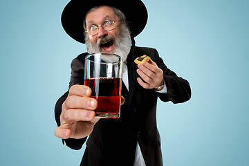 Image showing The senior orthodox Jewish man with black hat with Hamantaschen cookies for Jewish festival of Purim