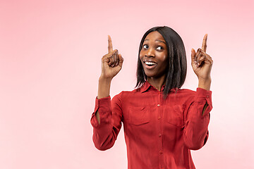 Image showing The happy african woman standing and smiling against red background.