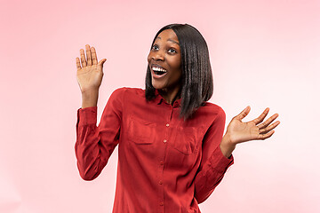Image showing The happy african woman standing and smiling against red background.