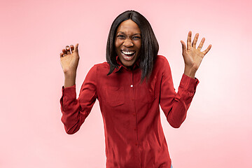 Image showing The happy african woman standing and smiling against red background.