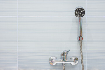 Image showing Blue tiled shower mixer and shower head