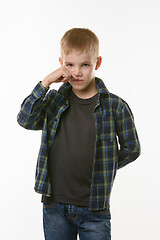 Image showing A ten year old boy wipes his nose with his finger
