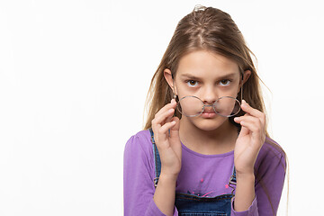 Image showing Teen girl takes off glasses isolated on white background