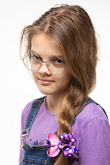 Image showing Portrait of a girl of eleven in round glasses and a long braid