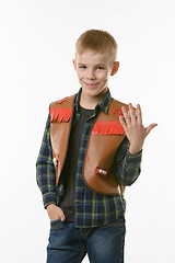 Image showing Portrait of a boy in a cowboys vest and raising his hand