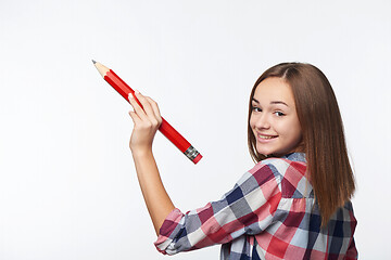 Image showing Teen girl writing with big pencil on copy space