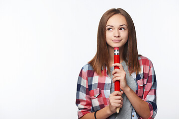 Image showing Smiling girl holding big pencil and looking to the side