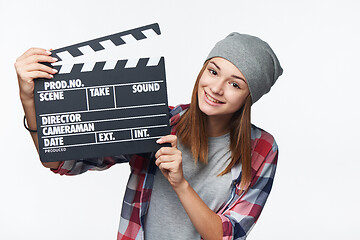 Image showing Smiling teen girl holding clap board