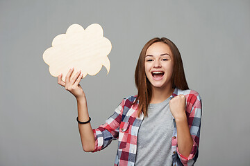 Image showing Smiling girl holding thinking bubble looking at camera