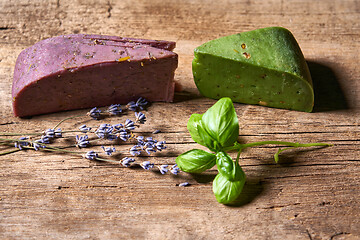 Image showing Gourmet lavender and pesto cheeses on rough wooden planks