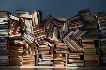 Image showing Wall of books piled up in the attic