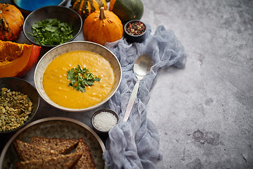 Image showing Pumpkin soup decorated with parsley for Thanksgiving, halloween.