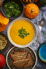 Image showing Pumpkin soup decorated with parsley for Thanksgiving, halloween. Placed on grey stone background