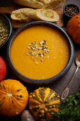 Image showing Homemade vegetarian pumpkin cream soup served in ceramic bowl. Decorated with seeds