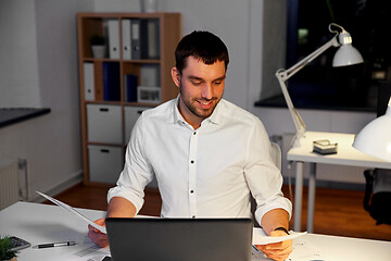 Image showing businessman with papers working at night office