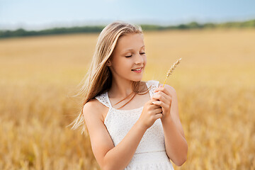 Image showing girl with spikelet of wheat on cereal field